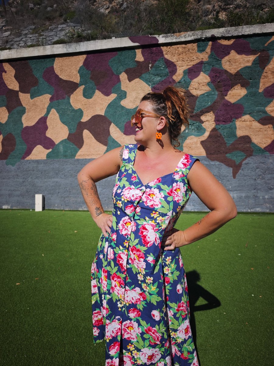 Chloé en robe fleurie bleue et rose, souriante